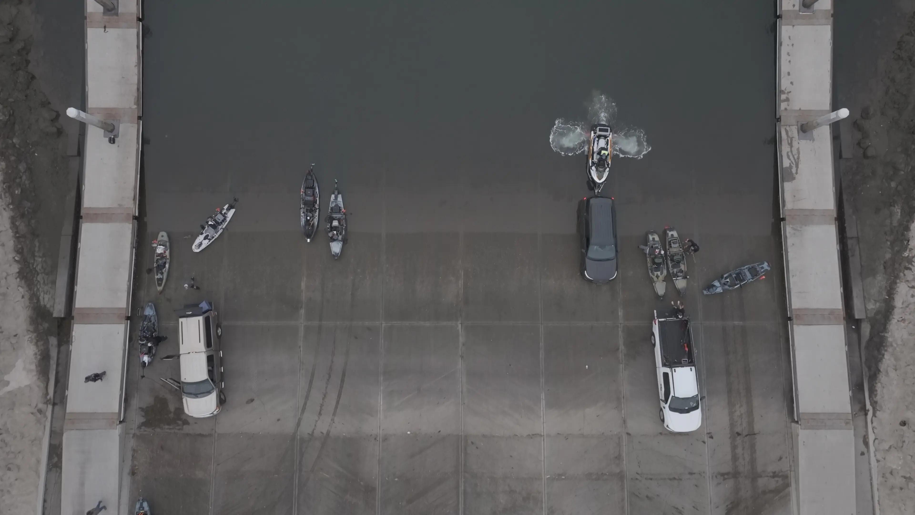 Aerial view of kayak anglers launching together at a boat ramp